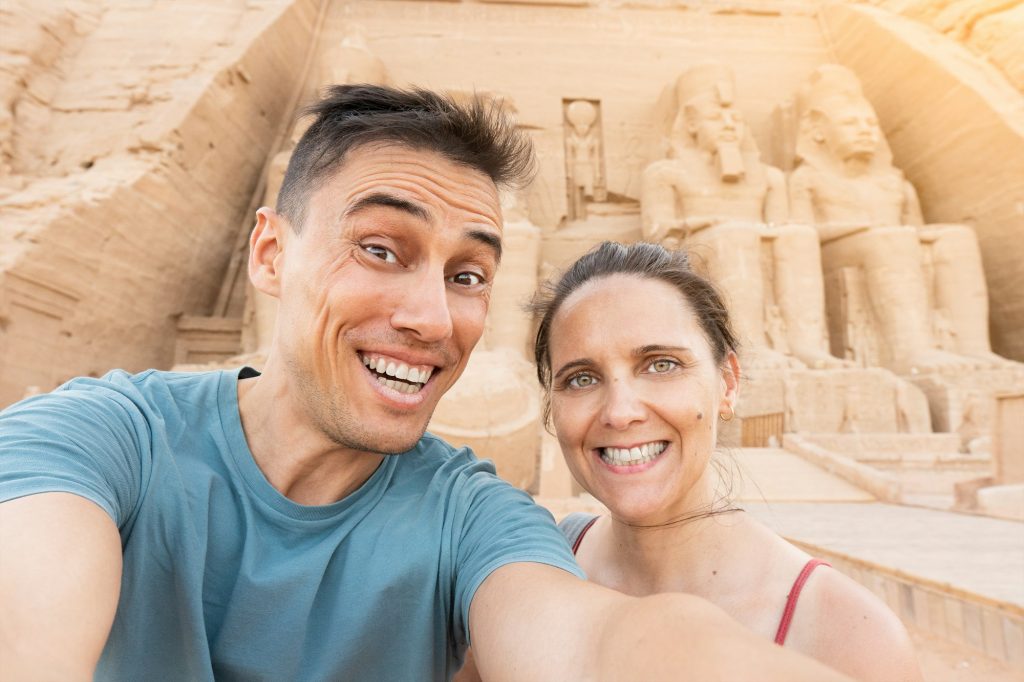 Tourist taking a selfie in front of an egyptian temple