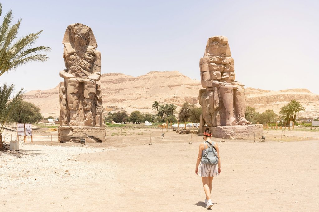 Woman walking towards an ancient egyptian statues